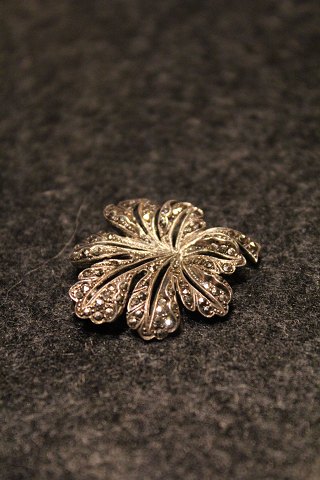 Old brooch in silver with lots of little shiny magasiter.