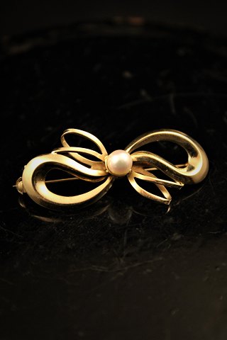 14 karats guld broche med perle.Længde: 4cm.