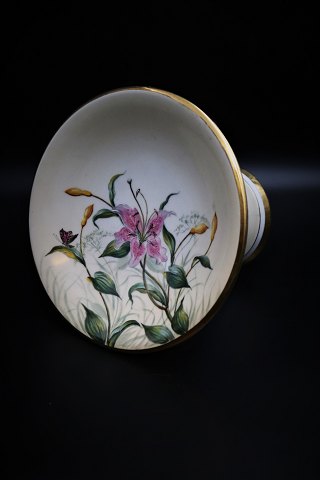 Antique 1800 century cake stand from Bing & Grondahl with hand-painted lilies 
decorated with gold edge. H:17,5cm. Dia.:24cm.