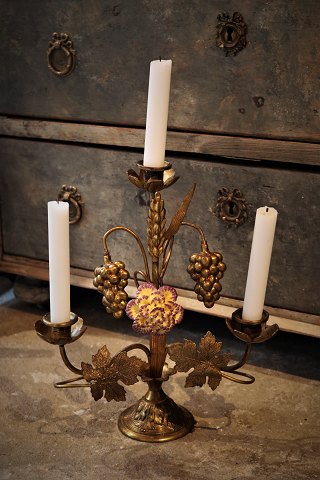 Old French church candlestick in gilded bronze decorated with 1 fine old colored porcelain flower. H:33cm. W:28cm.