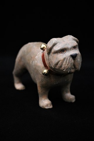 Gammel hund i bemalet papmaché / gips med en rigtig fin patina oglæder halsbånd med klokker på.H:8,5cm. L:14cm.