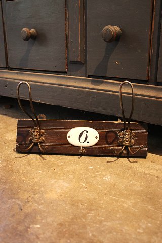 Old wooden coat rack with 2 metal coat hooks with mesh, a key hook and an old 
number plate...