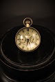 Gammelt Omega bord ur i form af glaskugle montage af messing , med hvid urskive med sorte romertal og mekanisk urværk.