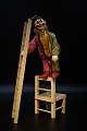 Gammel fransk cirkus legetøjs klovn i bemalet træ med klovnetøj i stof samt stol og stige i træ.Klovn H:22cm.
